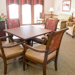 A cozy living room setting with a wooden dining table and upholstered chairs.