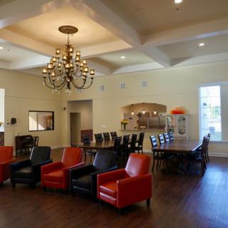 A spacious living area featuring colorful chairs, a dining table, and elegant lighting.
