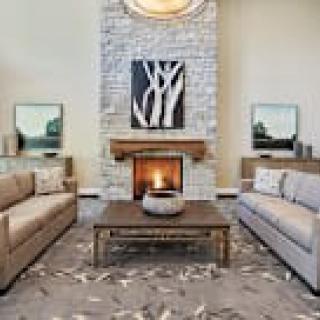 A stylish living room featuring a modern fireplace, elegant sofas, and tasteful artwork.