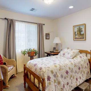 A cozy bedroom with floral bedding and a window view.