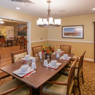 A well-set dining room table with elegant decor and a chandelier overhead.
