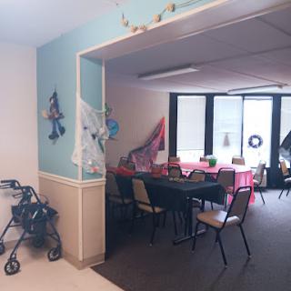 A cozy activity room with decorated tables and accessible seating.