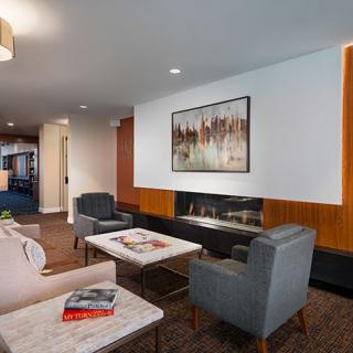 A modern living room featuring stylish seating, a coffee table, and artwork on the wall.