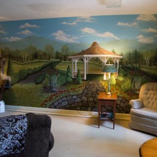 A cozy living room featuring a beautiful mural of a gazebo surrounded by a serene landscape.