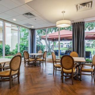 A spacious restaurant dining area with elegant furniture and large windows allowing natural light.