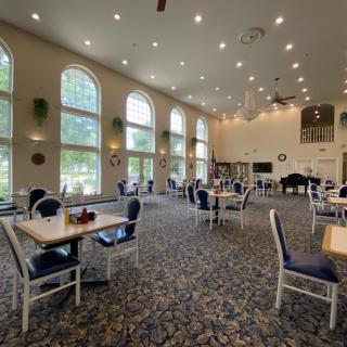 A spacious dining area with large windows and neatly arranged tables and chairs.