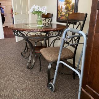 A cozy interior featuring a dining table set with flowers and a walker nearby.