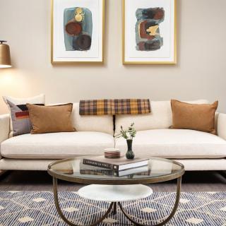 A modern living room with a stylish sofa, abstract artwork, and a decorative coffee table.