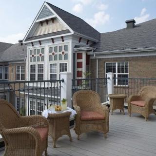 A cozy outdoor patio with wicker furniture and a view of a charming building exterior.