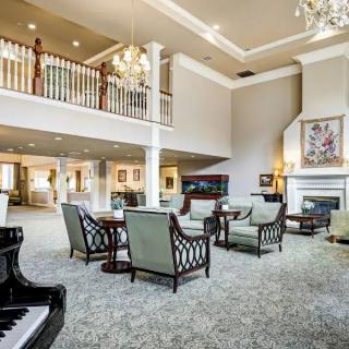 A spacious and elegant hotel lobby with luxurious furnishings, featuring a grand piano and chandelier lighting.