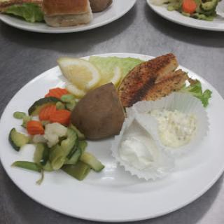 A diverse meal featuring cooked meat, a side of vegetables, and salad.
