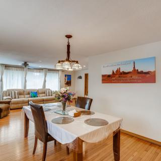 A cozy dining area with a table set for two, adjacent to a comfortable living room.