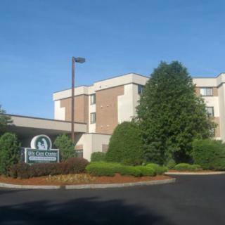 Exterior view of a hotel with surrounding trees and landscaping.