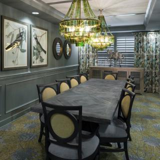 Elegant dining room with a large table, stylish chandelier, and artistic decor.