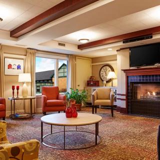 A cozy living room with a fireplace, comfortable seating, and elegant decor.