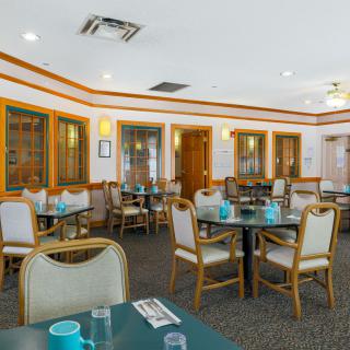Empty dining area in a restaurant with neatly arranged tables and chairs.