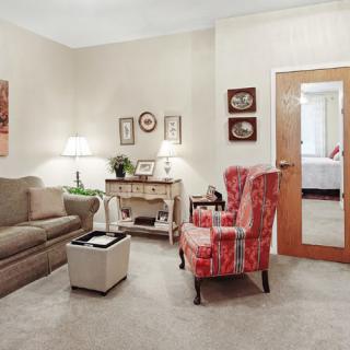 A cozy living room with a sofa, armchair, coffee table, and tasteful decor.