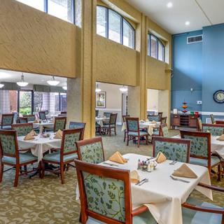A well-lit dining area featuring neatly arranged tables and chairs.