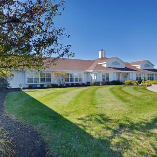 A suburban home with a manicured lawn and clear blue sky.