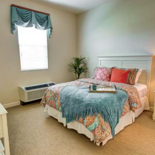 A cozy and modern bedroom with a neatly made bed and elegant decor.
