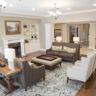 A spacious and elegantly designed living room featuring comfortable seating, a fireplace, and tasteful decor.