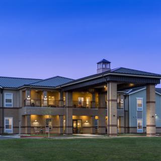 A well-lit residential building exterior at dusk.
