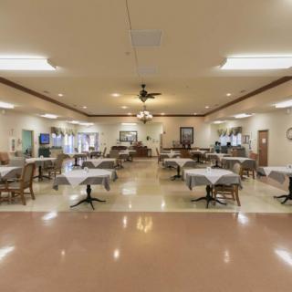 An empty dining room with neatly arranged tables and chairs.