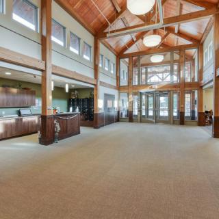 A spacious and modern lobby with wooden beams and a reception area.
