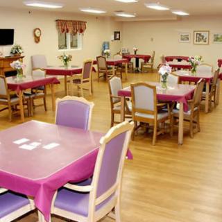 A well-organized dining area with tables covered in pink tablecloths and decorated with flowers.