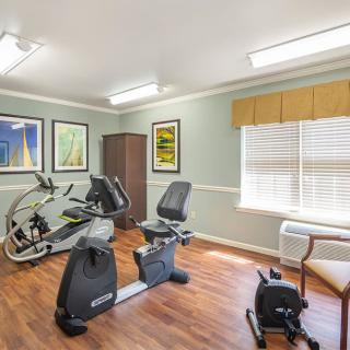 A small indoor exercise room with stationary bikes and bright lighting.
