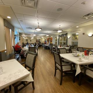 A spacious dining area with neatly arranged tables and chairs in a well-lit environment.