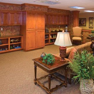 A cozy living room with wooden cabinets, a sofa, and decorative plants.