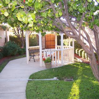 A serene garden with a white gazebo and a winding pathway.