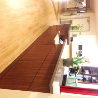 A reception desk in an office setting with plants and bookshelves.