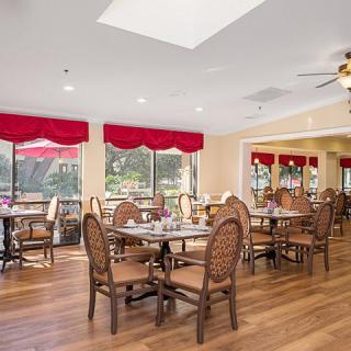 A bright and inviting dining area with wooden flooring and red accents.