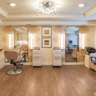 A modern beauty salon interior with chairs and mirrors.