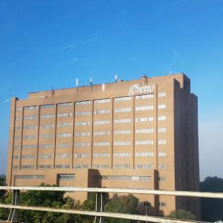 A large hospital building under a clear blue sky.