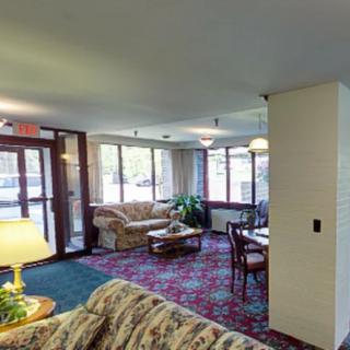 A cozy lobby area with sofas, a table, and large windows providing natural light.