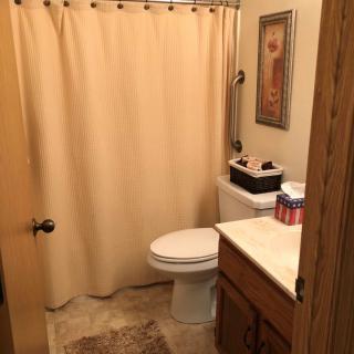 A small bathroom with a shower curtain, toilet, and sink.