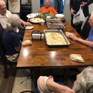 A family gathered around a table for a meal together.