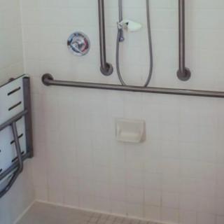 Accessible shower with grab bars for safety.