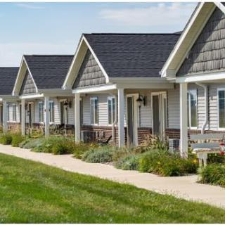 A row of suburban houses with well-maintained lawns and pathways.