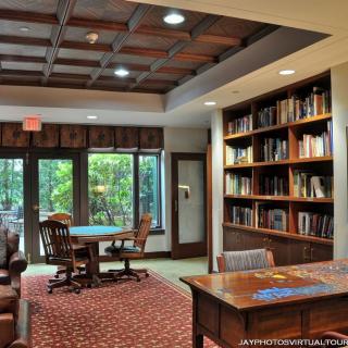 A cozy library reading room with shelves filled with books and comfortable seating.
