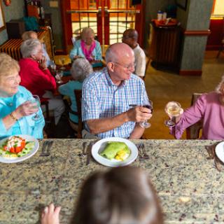 A joyful gathering of seniors sharing a meal and enjoying each other's company.