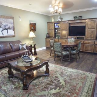 A cozy living room with classic furniture and a large rug.
