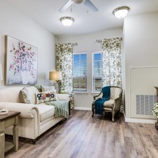 A cozy living room featuring a comfortable sofa, armchair, and stylish decor with large windows letting in natural light.
