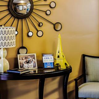 A stylish corner of a living room featuring modern decor elements, including a decorative mirror and an Eiffel Tower replica.