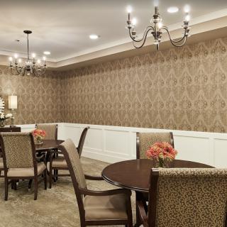 Elegant dining room with chandeliers and patterned wallpaper.