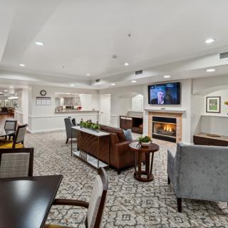 A cozy and modern living room with a seating area, fireplace, and television.