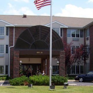 A multi-story building with an entrance canopy and an American flag in front.